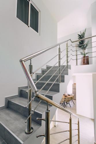 a staircase with stainless steel railings and a table at Casa Sun's Buddy in Willemstad