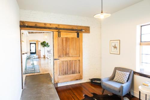 a living room with a wooden door and a chair at Lander Millhouse in Lander