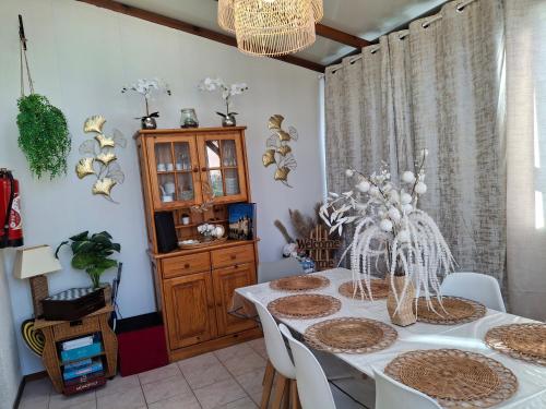 a dining room with a white table with white chairs at maison village 4 chambres 30 minutes du zoo de beauval in Saint-Cyran-du-Jambot