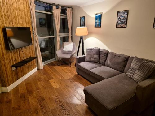 a living room with a couch and a television at Ultra-Luxury City centre 2 bed apartment, with FREE parking in Cardiff