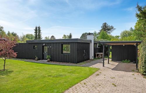 a black modular house with a backyard at 2 Bedroom Beautiful Home In Gilleleje in Gilleleje