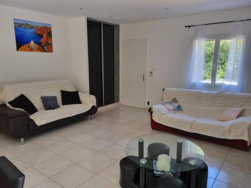 un salon avec deux canapés et une table en verre dans l'établissement Villa Stellalilou, à Porto-Vecchio