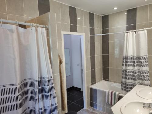 La salle de bains est pourvue d'un rideau de douche, d'un lavabo et d'une baignoire. dans l'établissement Villa Stellalilou, à Porto-Vecchio