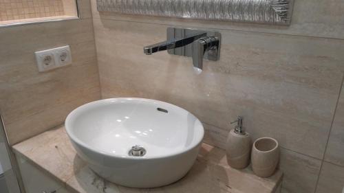 a bathroom with a white sink and a faucet at Apartman Roma in Brčko