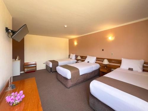 a hotel room with two beds and a table at DM Hoteles Arequipa in Arequipa