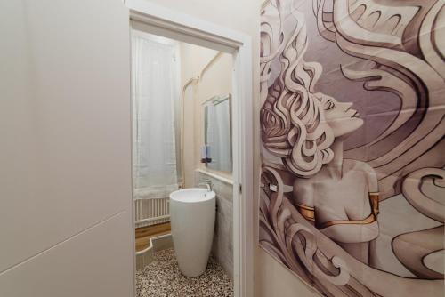 a bathroom with a painting of a woman on the wall at Le Diel rooms & breakfast in Genova