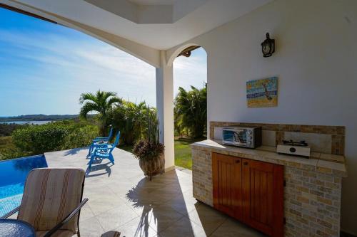 an outdoor kitchen with a view of a pool at Casa Nero Panama in Boca Chica