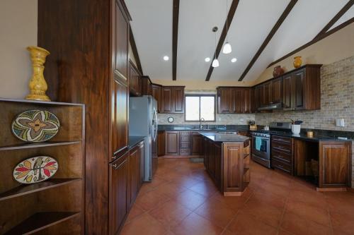 a large kitchen with wooden cabinets and stainless steel appliances at Casa Nero Panama in Boca Chica