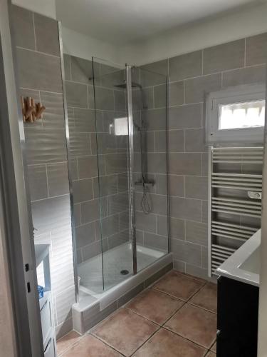 une douche avec une porte vitrée dans une salle de bain dans l'établissement Rez Haut de villa à Calenzana, à Calenzana