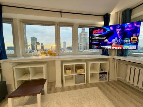 a living room with a flat screen tv and a large window at Sawa 7 WiFi8Gbs 85'TV 4K Netflix in Warsaw