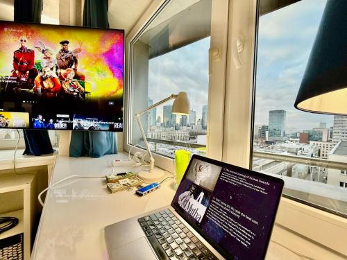 a laptop computer sitting on a desk in front of a window at Sawa 7 WiFi8Gbs 85'TV 4K Netflix in Warsaw