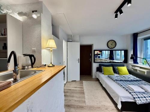 a bedroom with a bed and a kitchen with a sink at Sawa 7 WiFi8Gbs 85'TV 4K Netflix in Warsaw