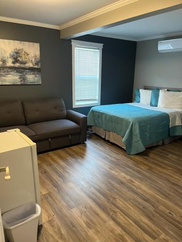 a bedroom with a bed and a couch at Stanley House Motel in Clarenville