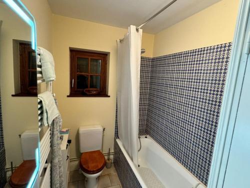 une salle de bain avec toilettes, baignoire et lavabo dans l'établissement La Grange, la Lande St Leger, à La Lande