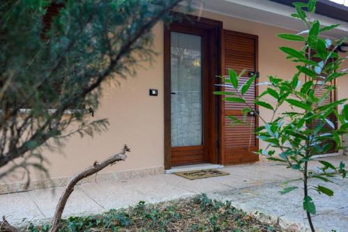 a house with a wooden door and a tree at Casa delle Magnolie in Pedemonte