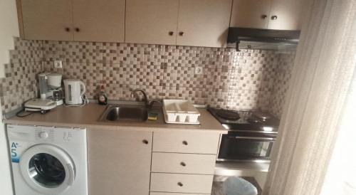 a kitchen with a sink and a washing machine at Kavala Amazing View in Kavala