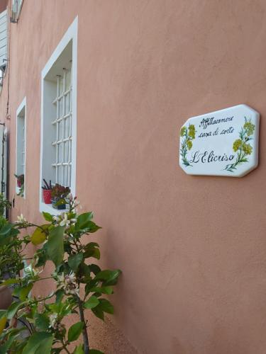 a sign on the side of a building with a window at Casa Elicriso in Montecarlo