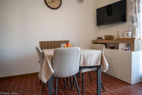 a dining room table with chairs and a tv on the wall at Casa delle Magnolie in Pedemonte