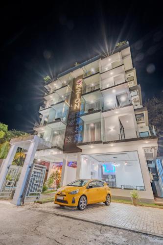 a yellow car parked in front of a building at Mzion Hotel Weligama in Weligama