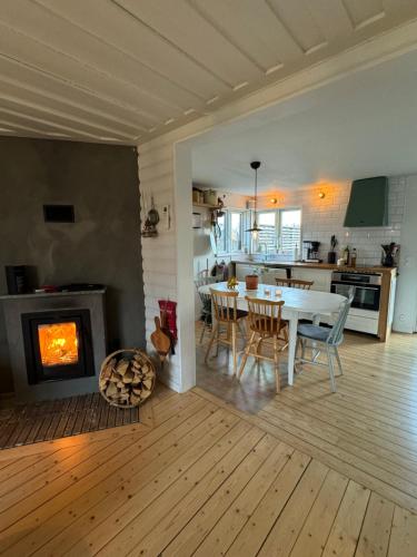 a kitchen and living room with a table and a fireplace at Boende på Marholmen in Norrtälje