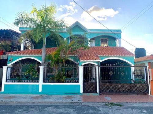 una casa azul con una puerta y una palmera en Casa-hogar moises, en Los Tres Brazos