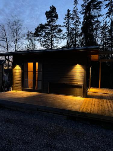a house with a wooden deck at night at Boende på Marholmen in Norrtälje