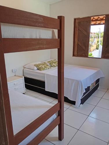 a bedroom with two bunk beds and a window at Nirvana Pipa in Pipa