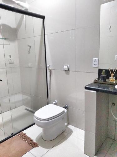 a white bathroom with a toilet and a shower at Nirvana Pipa in Pipa