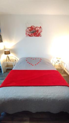 a bedroom with a red blanket on a bed at Studio Les coquelicots in Saint-Romain-sur-Cher