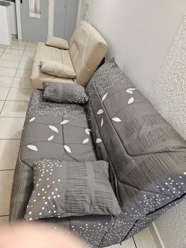 Cette chambre comprend un lit avec des oreillers et un canapé. dans l'établissement Studio Au Bord de la Mer 2, au Cap d'Agde