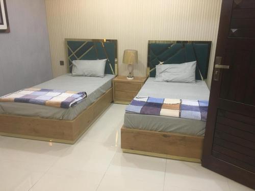 two beds in a hotel room with sidx at Crown Inn Furnished Apartments in Khaira Gali