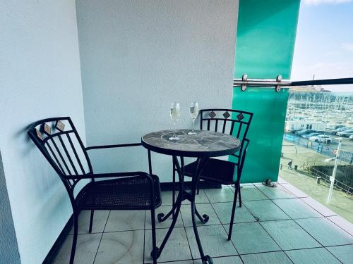 a table and two chairs on a balcony with a view at Pears Suite - 1 Bedroom - Sleeps 2 in Whitehaven
