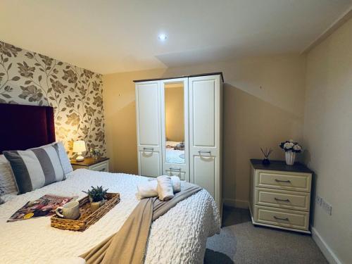 a bedroom with a bed with a dresser and a mirror at Pears Suite - 1 Bedroom - Sleeps 2 in Whitehaven