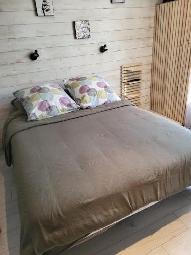 - un grand lit avec deux oreillers dans une chambre dans l'établissement De la mer, à Colleville-Montgomery