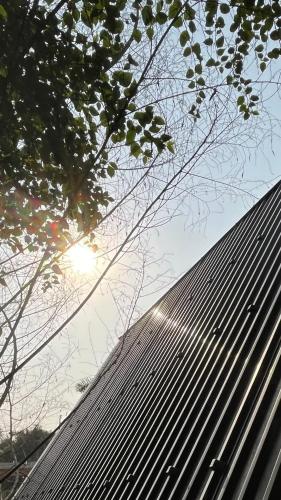 a black roof with the sun in the background at Kayla Homestay - Bungalow Rose Double in Ba Vì