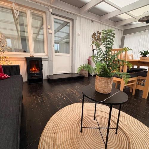 a living room with a table and a fireplace at Sikvägen Apartments in Mariehamn
