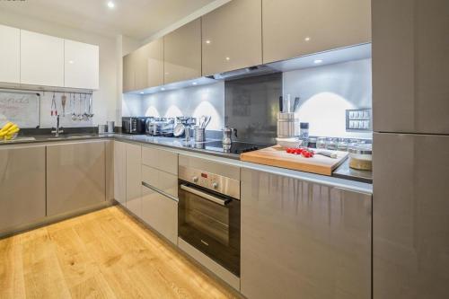 a kitchen with stainless steel appliances and wooden floors at 4 Beds Luxury Flat with the Best London View in London