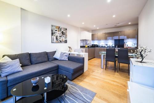a living room with a blue couch and a kitchen at 4 Beds Luxury Flat with the Best London View in London