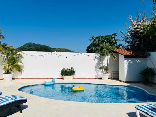 a swimming pool with two inflatable toys in it at Paraiso Escondido in Lo de Marcos