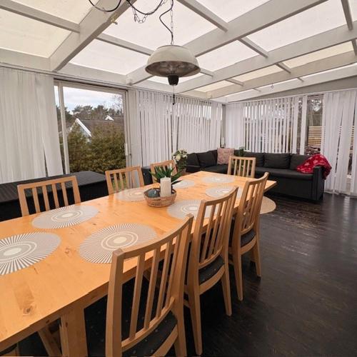 a dining room with a large wooden table and chairs at Sikvägen Apartments in Mariehamn