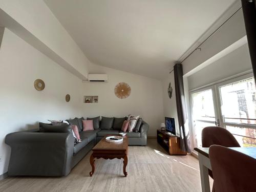 a living room with a gray couch and a table at La maison du Baron in Uzès
