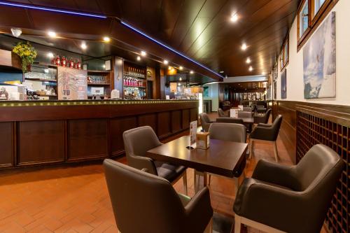 a restaurant with tables and chairs and a bar at Resort Palace Sestriere 1 e 2 in Sestriere