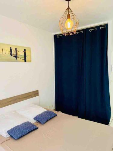 - une chambre avec un rideau bleu et un lit avec deux oreillers dans l'établissement Charming apartment 100m from the beach, à Antibes