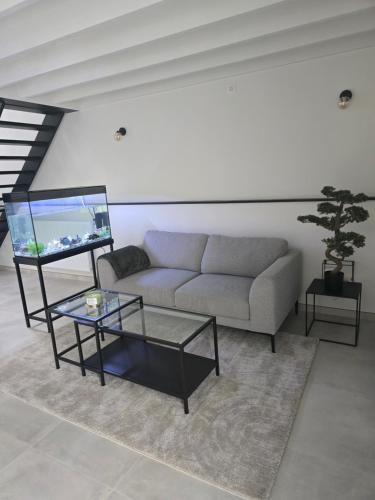 a living room with a couch and a fish tank at Aqua Loft Suite exécutive & élégante Quartier Européen Bruxelles in Brussels