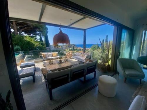 un salon avec une table et une grande fenêtre dans l'établissement Villa Miou, à Cassis