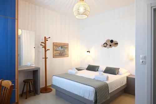 a bedroom with a bed and a table and a lamp at Oneiro Rooms Kythnos in Kanala
