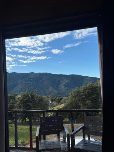 a window with two benches looking out at the mountains at Cabaña La Trinidad de Dota in El Copey
