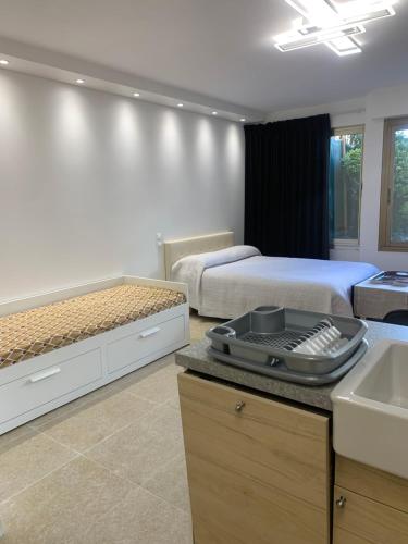 une chambre avec deux lits et une cuisine avec un évier dans l'établissement STUDIO VIEIL ANTIBES, à Antibes