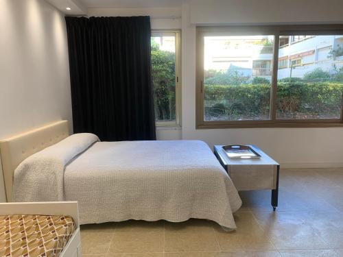 une chambre avec un lit, une table et une fenêtre dans l'établissement STUDIO VIEIL ANTIBES, à Antibes