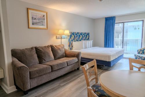 un salon avec un canapé et un lit dans l'établissement Recently Updated Oceanview King Suite! Sea Mist 50504! Sleeps 4!, à Myrtle Beach